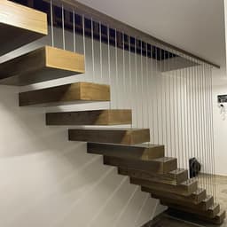 Scara cu trepte metalice suspendate placate cu trepte casetate din lemn de frasin