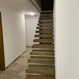 Scara cu trepte metalice suspendate placate cu trepte casetate din lemn de frasin