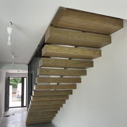 Scara cu trepte metalice suspendate placate cu trepte casetate din lemn de stejar